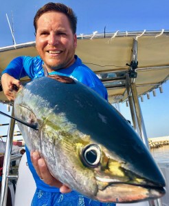 Close-up of an angler holding a yellowfin tuna caught on a Hamachi rod